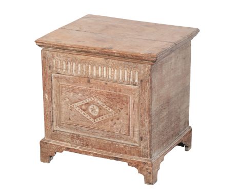 A LIMED OAK LIDDED BOX 18th century, the hinged lid opening to a vacant interior, with lozenge carved front, on shaped bracke