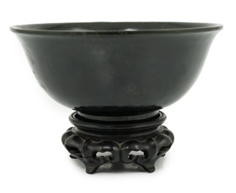 A Chinese dark spinach green jade bowl, engraved Qianlong seal mark but 19th/20th century, the slightly flared bowl with circ