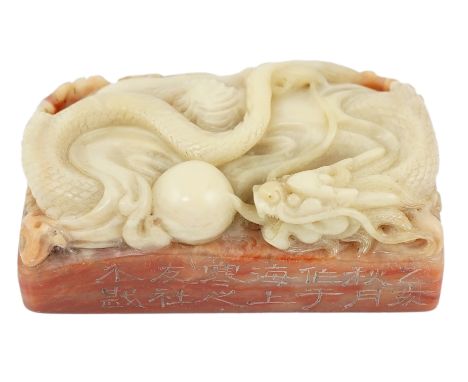 A Chinese 'dragon' soapstone inscribed seal, carved in high relief with a dragon chasing a flaming pearl, and incised with an
