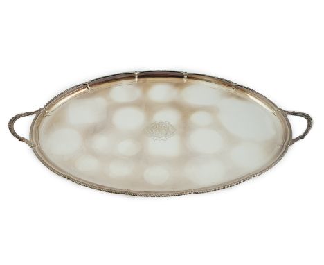 An Edwardian silver oval two handled tea tray, by George Howson, with shaped gadrooned border and engraved monogram, Sheffiel