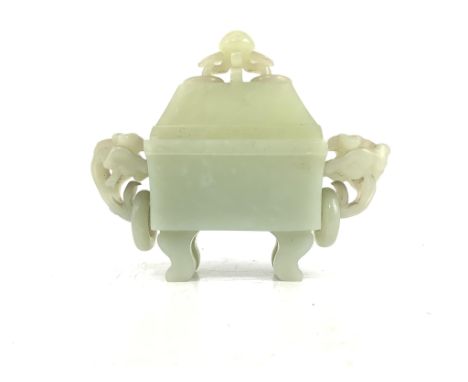 A Chinese pale celadon jade rectangular vase and cover, 19th/20th century, with a pair of lotus ring handles, on four curved 