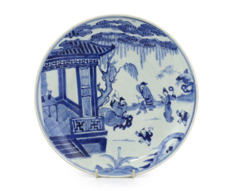 A Chinese blue and white dish, Kangxi period, painted with musicians and a dancer in a pavilion garden setting, four characte