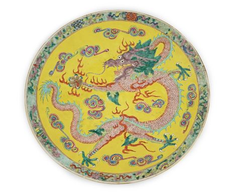 A Chinese yellow ground ‘dragon’ dish, late 19th century, painted with a five claw dragon chasing a flaming pearl on a yellow