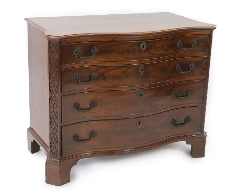 A George III Chippendale serpentine mahogany chest of four graduated long drawers flanked by blind fretwork angles, on bracke