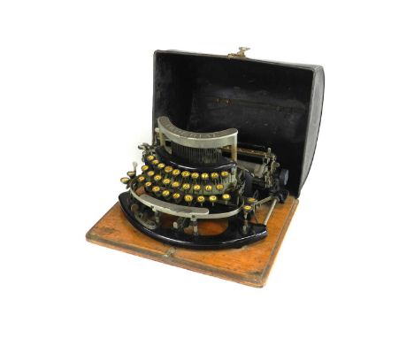 An Imperial Model-B portable typewriter, on wood base with tin domed cover, 31cm wide, base 34cm wide.Condition report: Some 