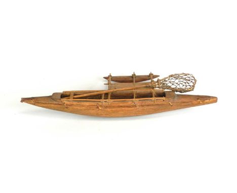 A South Pacific Polynesian Samoan model outrigger canoe with tools including paddles and catching net, 36cm long.
