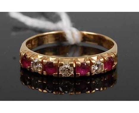 An 18ct gold, ruby and diamond half eternity ring, arranged as seven alternating round cut rubies and diamonds, total diamond