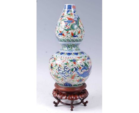 A Chinese export vase of double gourd form, enamel decorated with a Chinese five clawed dragon chasing a flaming pearl, havin