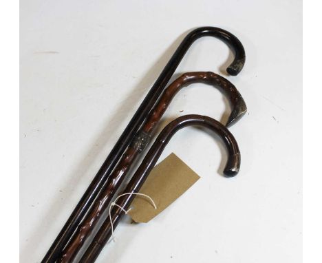 An early 20th century silver mounted walking stick, 91cm, together with two others similar (3)
