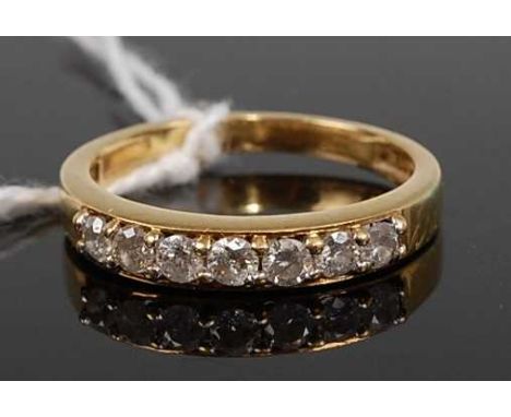 An 18ct gold diamond half eternity ring, arranged as seven channel set brilliants, total diamond weight stated as 0.5 carats,