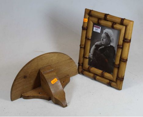 A monochrome photograph of Queen Victoria, within a rectangular bamboo frame; together with a pine semi-circular wall bracket