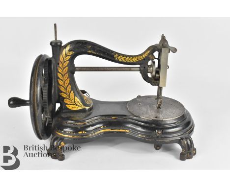 A Jones and Co. Serpentine hand crank sewing machine, and Chad Valley Queen Mother tin globe.