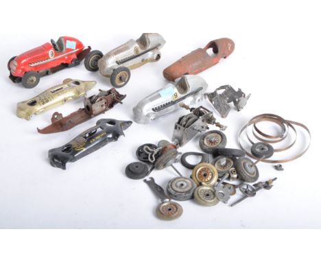 A collection of vintage German Schuco tinplate clockwork model car parts to include; base plates, wheels, motor parts and oth
