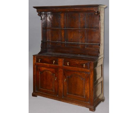 OAK DRESSER, mid 18th century, the two shelf rack with an overhang on a base with two fielded panel drawers above a pair of a