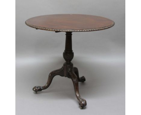 GEORGE III CIRCULAR TRIPOD TABLE, the top with a stiff leave carved rim on a turned and carved column and outswept legs with 