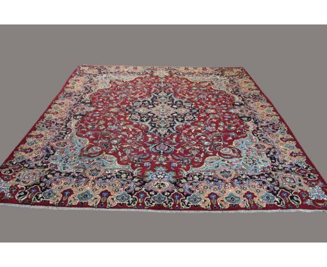 IRANIAN CARPET OF UNUSUAL SIZE, probably Khorasan, circa 1960, the raspberry field of vines around an indigo medallion framed