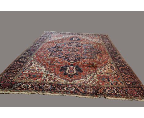 HERIZ CARPET, Iranian Azerbaijan, the madder field of angular vines around a typical medallion framed by stepped spandrels an