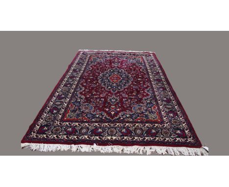 MASHAD CARPET, North Khorasan, second half of the 20th century, the raspberry field with a cusped floral medallion framed by 