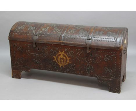 LEATHER BOUND AND BRASS STUDDED DOME TOP COFFER, or travelling trunk, 18th century and probably Italian or Spanish, with a pa