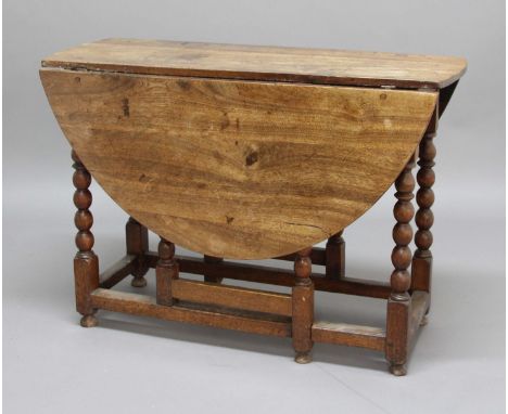WALNUT GATELEG DINING TABLE, the oval top on bobbin turned legs and block stretchers, height 75.5cm width open 132cm, depth 1
