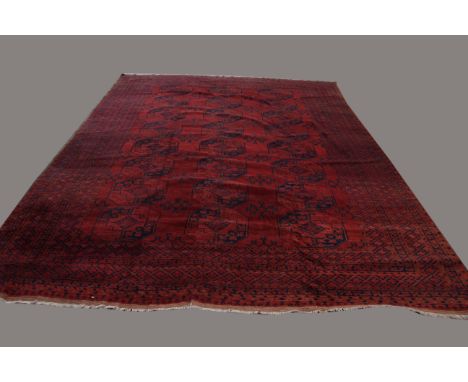 AFGHAN CARPET, probably circa 1950, the claret field with columns of elephant foot guls enclosed by multiple borders, 365cm x