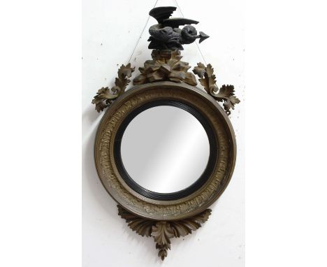 REGENCY STYLE GILT BULLS EYE MIRROR, the convex circular plate beneath a crouching dragon finial, height 85cm, width 46cm