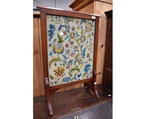 An Edwardian mahogany firescreen having tapestry panel