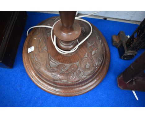 An Oriental carved standard lamp