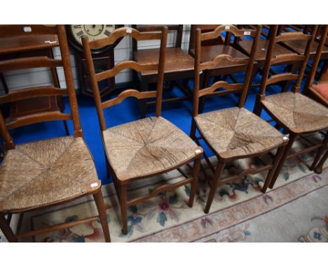Two pairs of rush seated kitchen chairs having shaped ladder backs