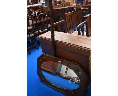 An early 20th Century oak wall mirror and a standard lamp (af)