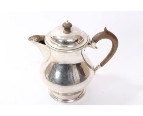 1920s silver hot water jug of baluster form, with sparrow beak spout, fruitwood handle and hinged domed cover with fruitwood 