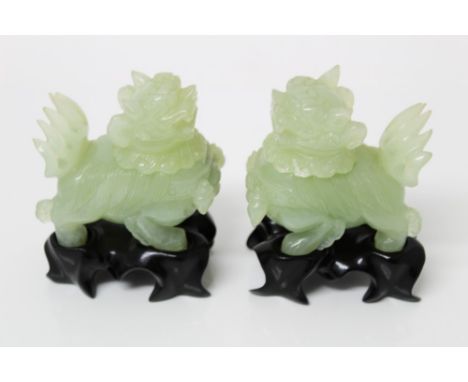 Pair of Chinese carved jade lidded vessels, each in the form of a temple dog, with removable head, 7cm high, on hardwood stan