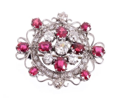 Ruby and diamond cluster brooch with a central cluster of five old cut diamonds alternating with four oval mixed cut rubies w