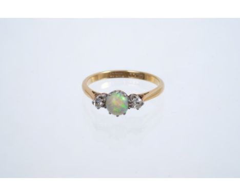 Early 20th century opal and diamond three-stone ring with a round opal cabochon flanked by two brilliant cut diamonds in plat