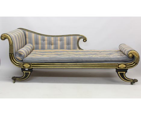 Fine Regency ebonised and parcel gilt chaise longue, the reeded show-wood frame with boss and leaf-scroll detail, striped but