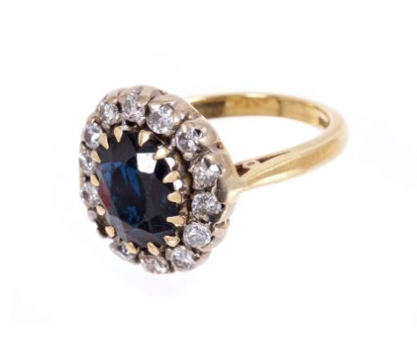 Sapphire and diamond cluster ring with an oval mixed cut blue sapphire measuring approximately 9.30 x 7.25 x 3.59mm, surround