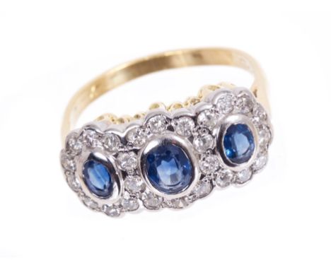 Sapphire and diamond triple flower cluster ring, with three oval mixed cut blue sapphires surrounded by a border of brilliant