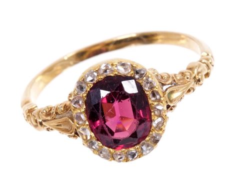 Almandine garnet and diamond cluster ring with an oval mixed cut garnet surrounded by a border of rose cut diamonds in gold s