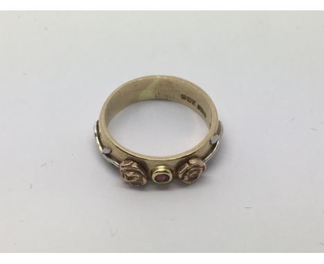 A 9ct gold ring set with a central ruby with flowers to either side, approx 4.9g and approx size P.