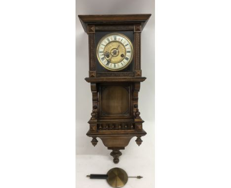 A German, carved wood wall clock with Roman Numeral dial and pendulum