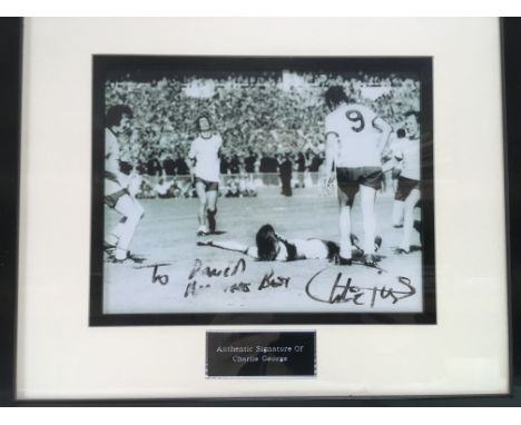 A signed Charlie George photograph, a signed book by Trevor Brooking, a 1958 West Ham Utd ticket, 1956 England program and a 