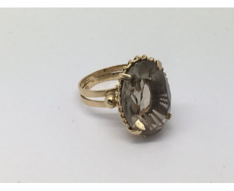 A gold ring, tested as 18ct, set with a large smoky coloured stone, approx 6.3g and approx size J-K.