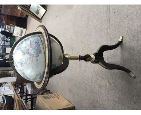 A reproduction free standing globe and a standing ships compass.