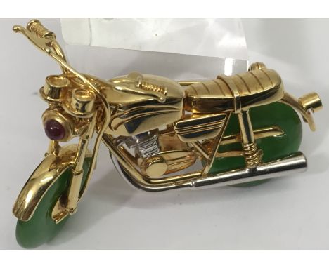An unusual 18ct gold motorcycle brooch, set with a ruby and jade wheels.Approx 5cm