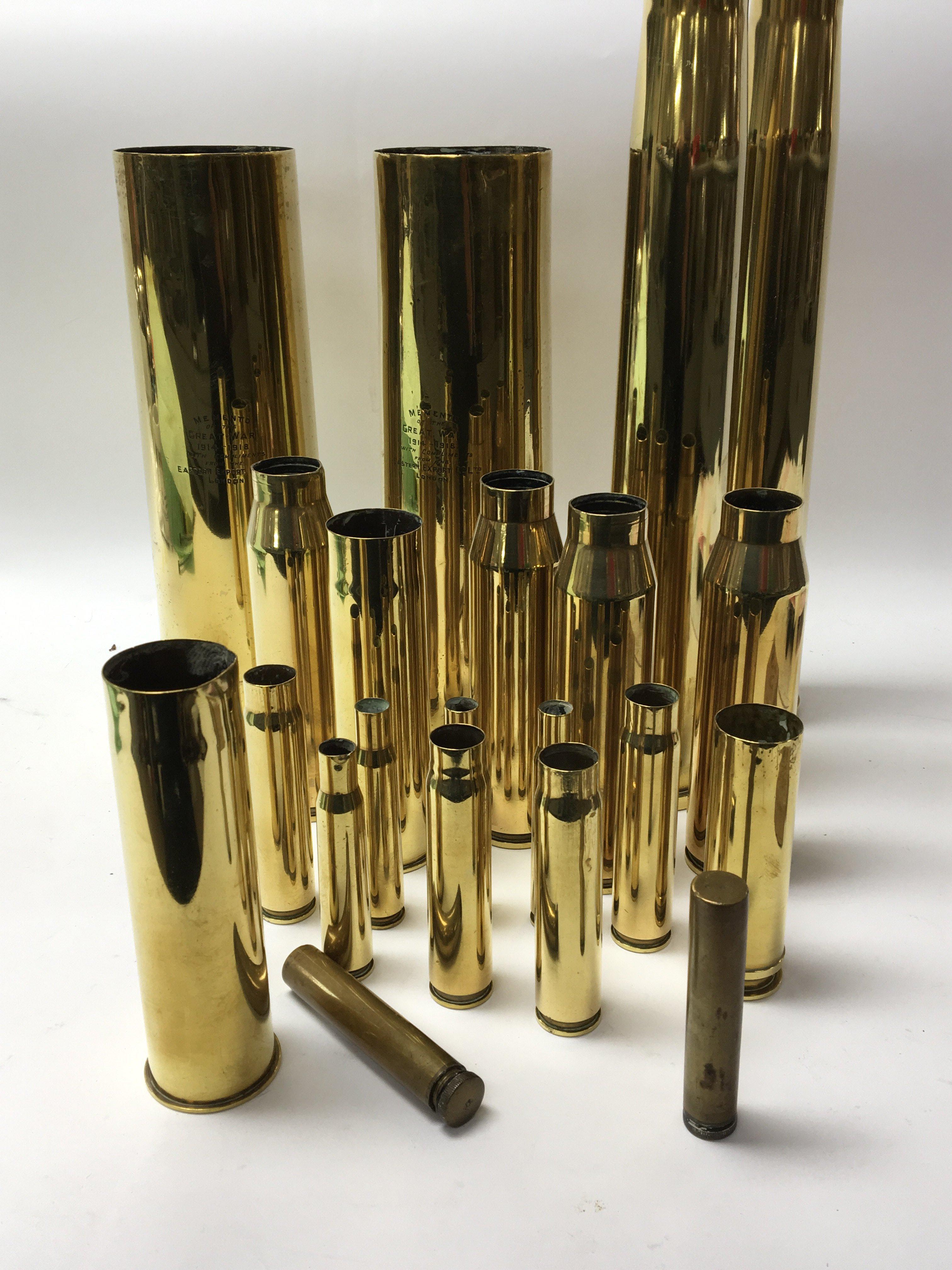 A collection of brass shell cases including two large cases with the