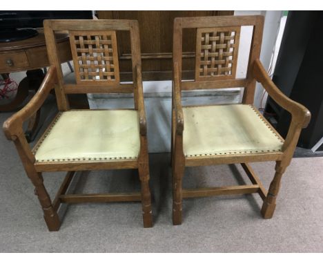 A pair of Robert Thompson Mouseman oak dining chairs, having open, woven splat backs, carved legs bearing mouse motif and yel