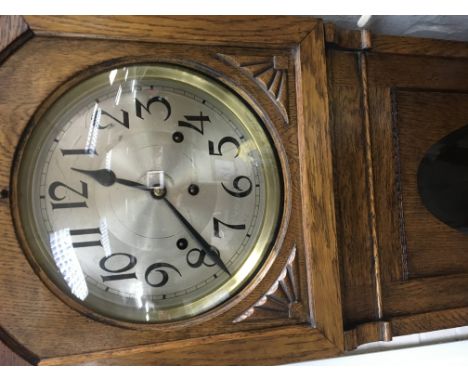 A oak cased grand mother clock the circular dial with Arabic numerals