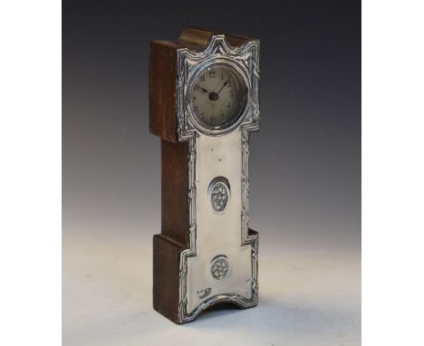 Early 20th Century silver faced oak mantel clock in the form of a longcase clock with Hamburg American dial over repoussé fro