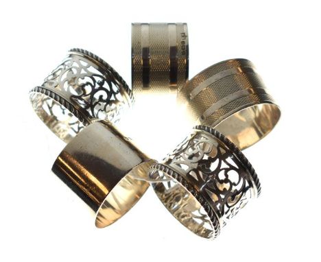 Five assorted silver napkin rings comprising: two pairs, the first with banded decoration, Birmingham 1946, the second pair p