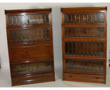 PAIR OF GLOBE WERNICKE FOUR TIER STACKING OAK BOOKCASES, with leaded glass and drawers to the base, one with a solid panelled